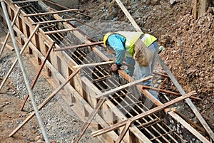 Group of construction workers fabricating ground beam formwork